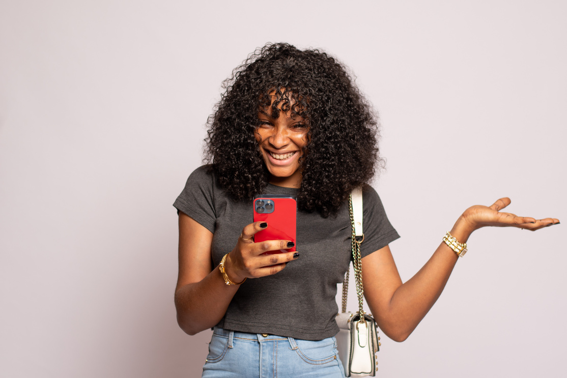 beautiful black lady checking her phone feeling excited